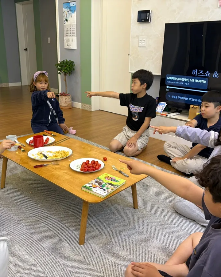 거실 탁자에 둘러앉아 이야기하는 소그룹
